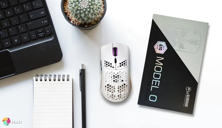 Glorious Model O Wireless Gaming Mouse on a white office desk with decorative items for a review