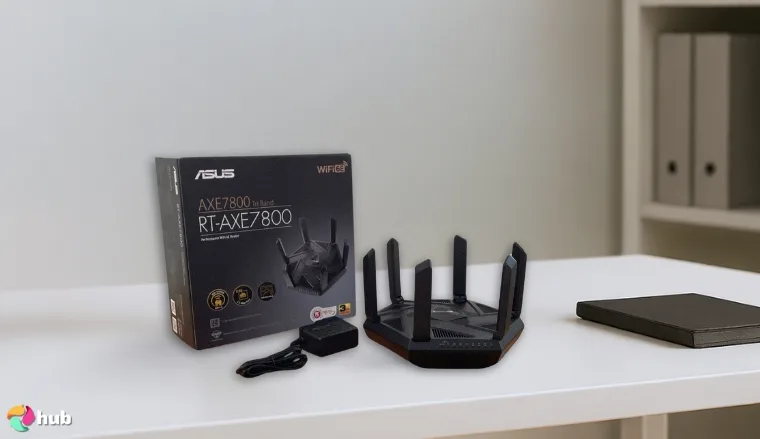 ASUS RT‑AXE7800 Gaming Router on a white office desk with natural shadows for a review