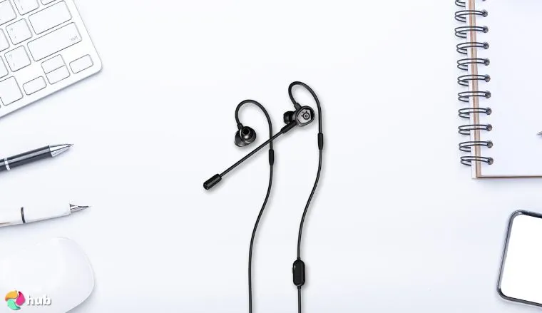 SteelSeries Tusq Gaming Earbuds on a white office desk in a bright workspace for a review