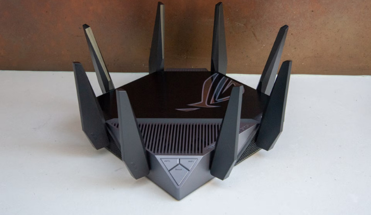 ASUS ROG Rapture GT-AXE11000 router with eight antennas on white surface background.