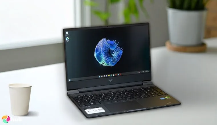 HP Victus 15 游戏笔记本电脑放在白色办公桌上,以自上而下的视角进行评测