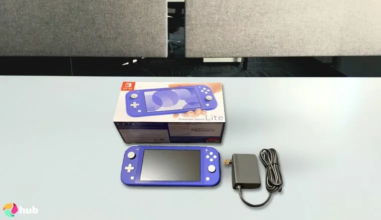 任天堂Switch Lite——蓝色游戏主机，摆放在白色办公桌上，环境整洁，准备进行评测。