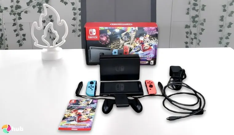 任天堂Switch – 马里奥赛车8豪华套装游戏主机摆放在白色办公桌上，俯视图用于评测。