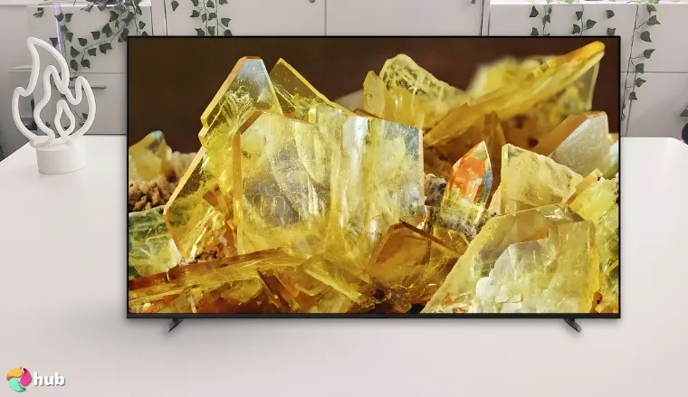 Sony 85-Inch X90L TV on a white office desk with soft lighting for a review