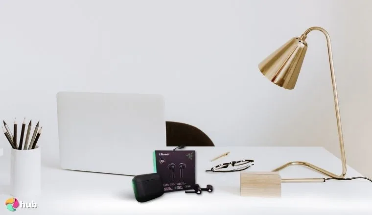 Razer Hammerhead True Wireless (2nd Gen) Earbuds on a white office desk set up for testing and review