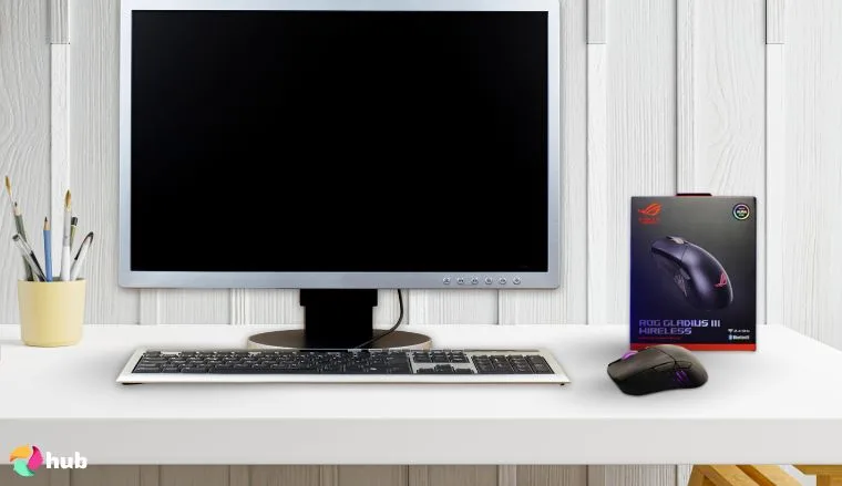 ASUS ROG Gladius III Mouse on a white office desk in a well-lit setting for a review