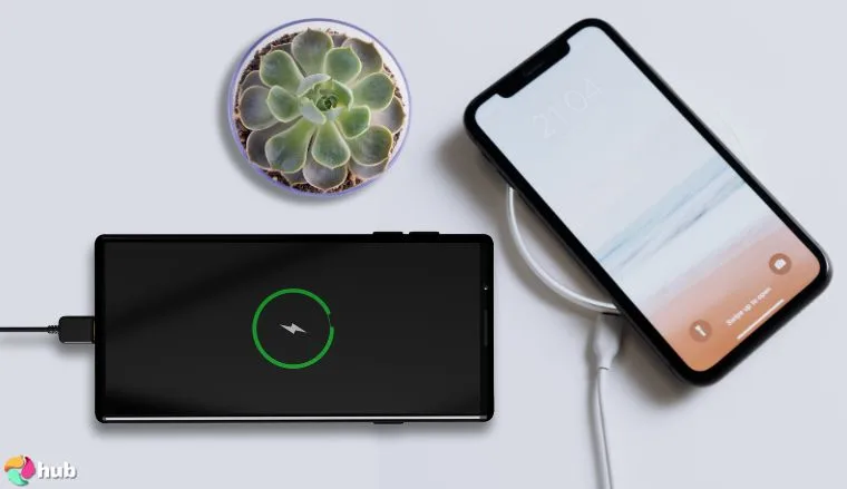Samsung and Apple smartphones charging on the white office table