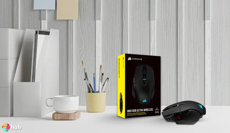 Corsair M65 RGB Ultra Wireless Tunable Gaming Mouse on a white office desk in a well-lit setting for a review