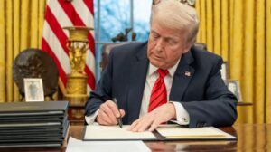 President Trump signing an executive order in the oval office.