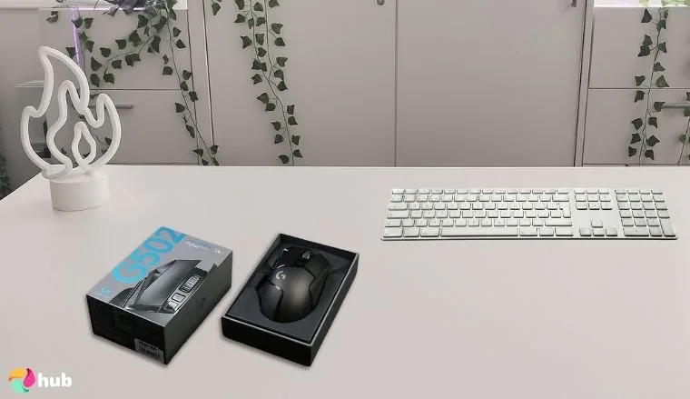 Logitech G502 HERO Gaming Mouse on a white office desk with minimal decor for a review