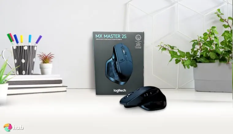 Logitech MX Master 2S Mouse on a white office desk with decorative items for a review