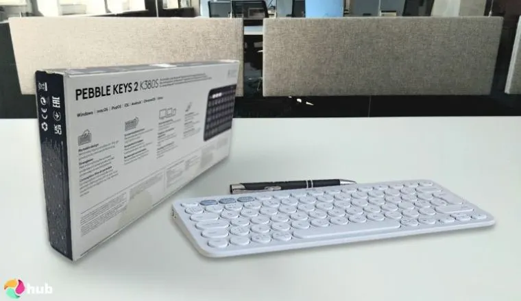 Logitech Pebble Keys 2 K380s Keyboard on a white office desk styled for promotional review