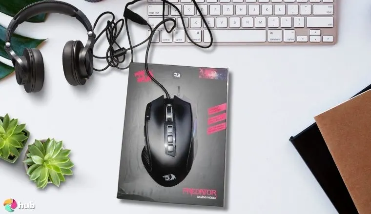 Redragon M612 Gaming Mouse on a white office desk in a top-down view for a review