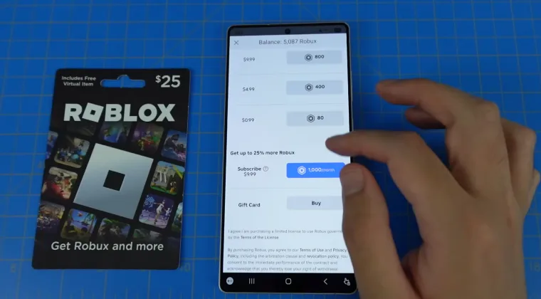Roblox gift card next to a smartphone