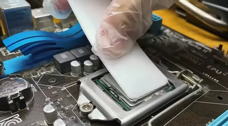 Applying thermal paste onto the surface of a CPU
