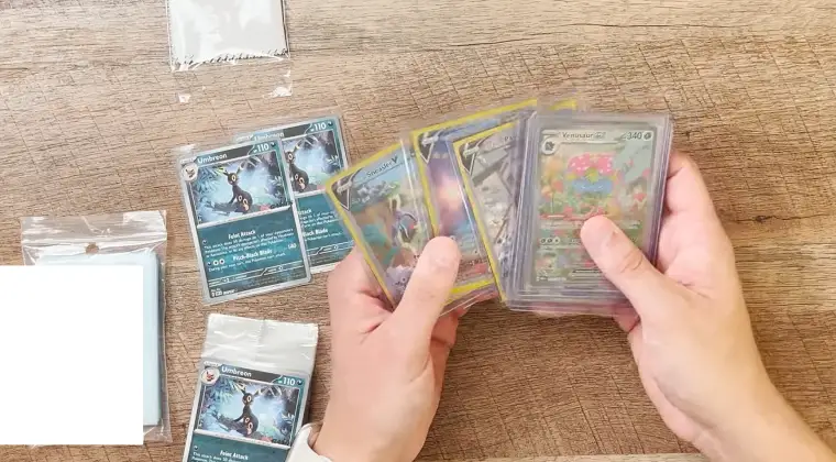 Trading cards on a table next to protective sleeves and cases for safeguarding them from damage.