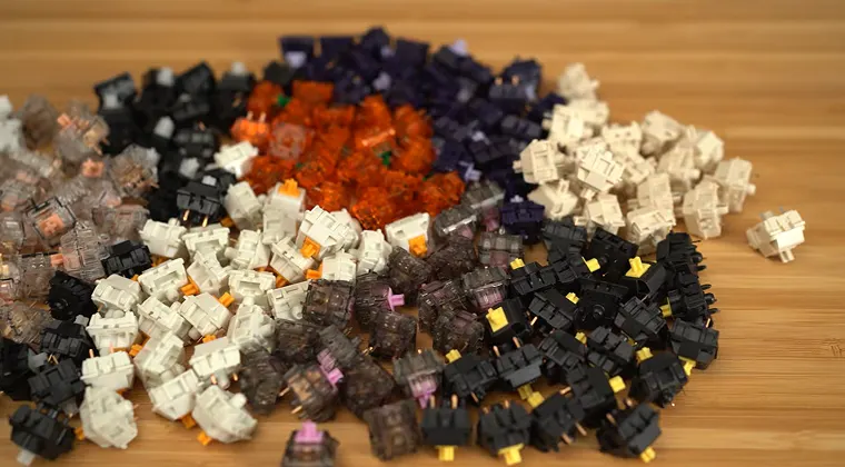 A large number of mechanical keyboard switches scattered across a table