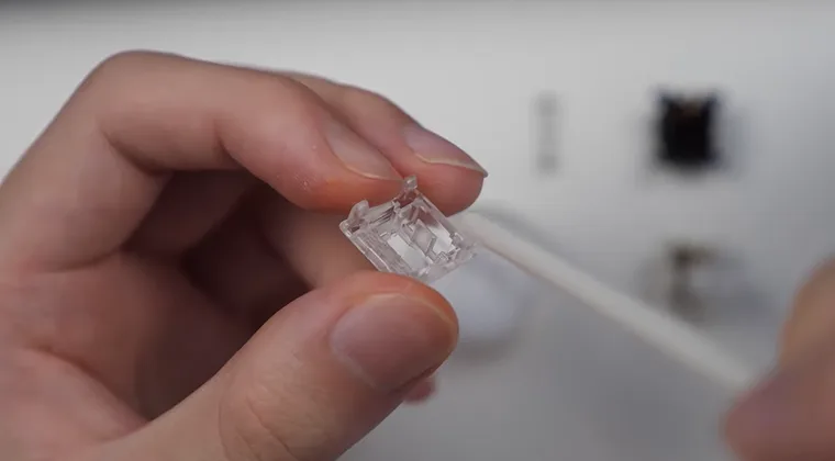 Cleaning the upper housing of a mechanical switch using a small tool or brush