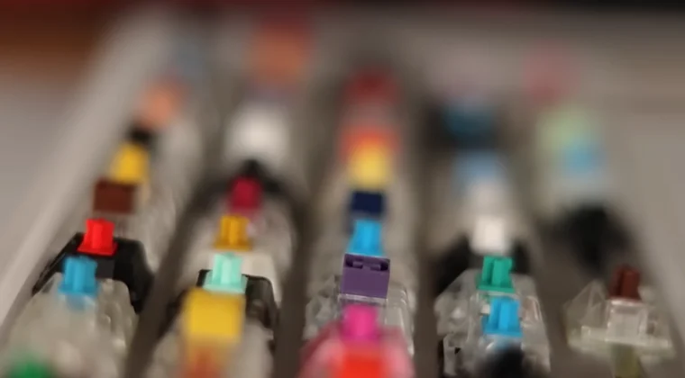 A row of mechanical keyboard switches lined up on a table