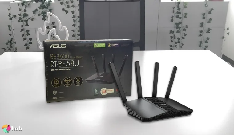 ASUS RT-BE58U Wi-Fi 7 Router on a white office desk in a bright workspace for a review