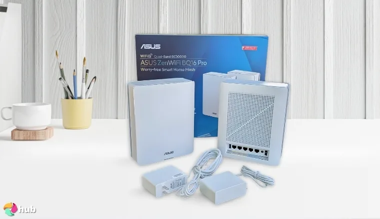 Asus ZenWi-Fi BQ16 Pro Mesh Wi-Fi System on a white office desk with soft lighting for a review