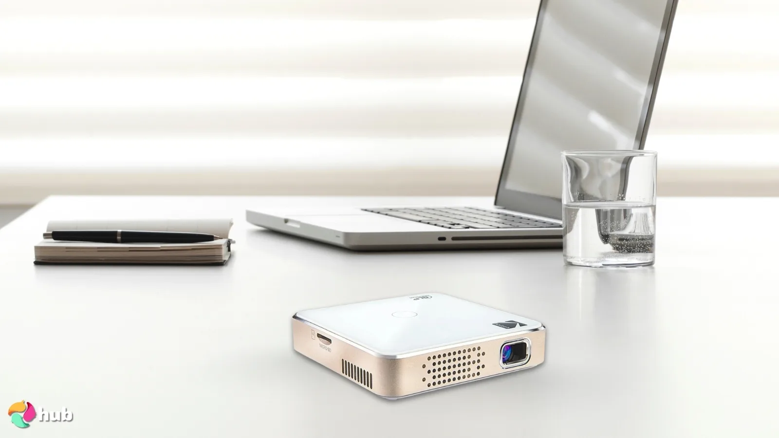KODAK Luma 150 Ultra Mini Pocket Projector on a white office desk in a top-down view for a review
