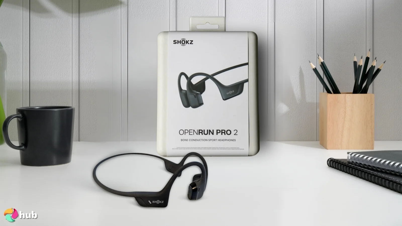 SHOKZ OpenRun Pro 2 Headphones on a white office desk in a top-down view for a review