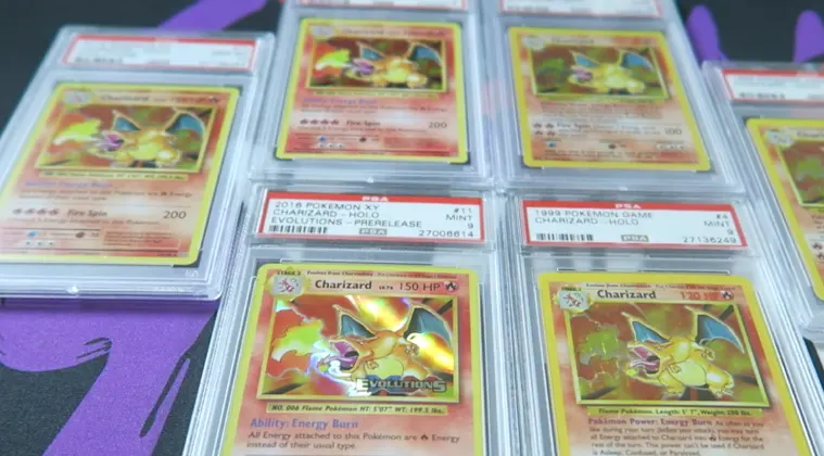 Several graded Pokémon cards laid out on a table