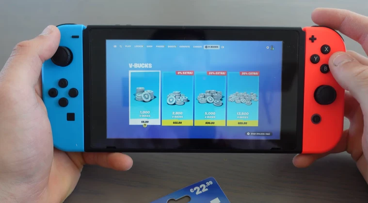 A Nintendo Switch held in hands displaying V-Bucks gift cards on the screen