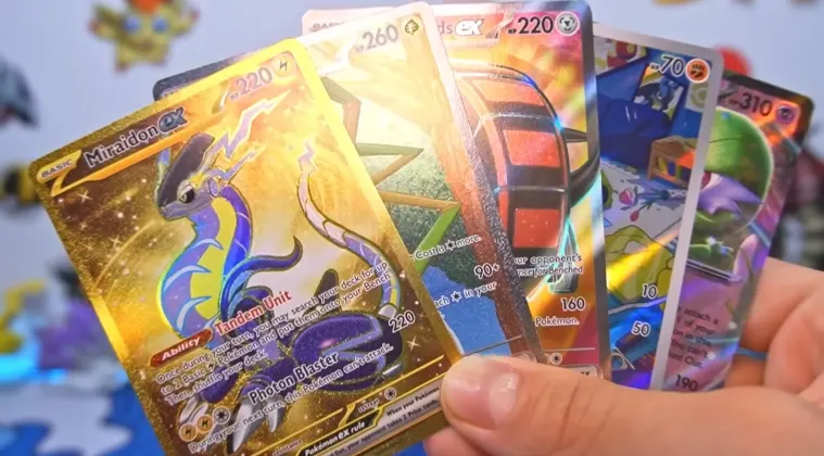 Several Pokémon cards held in a hand
