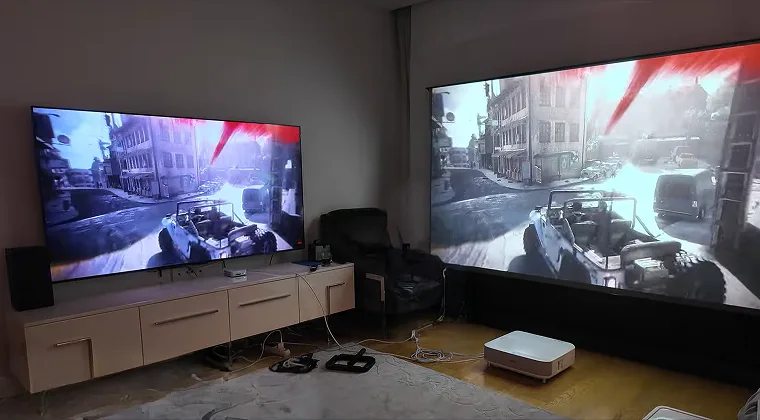 Room setup showing a game displayed on a projector next to a monitor for comparison