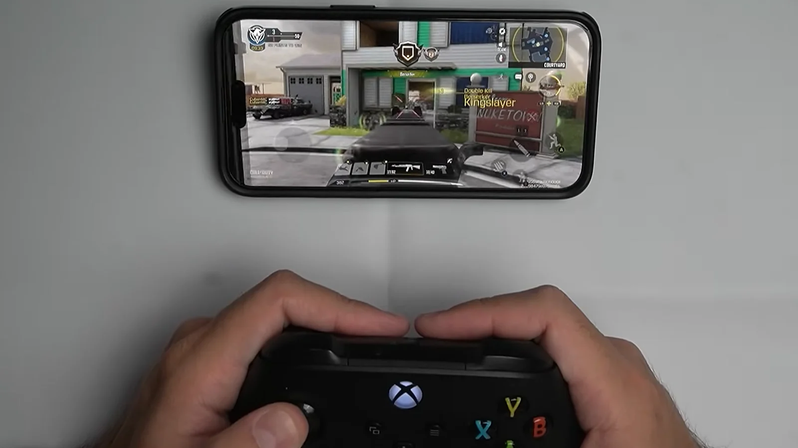A man playing COD mobile with an Xbox controller