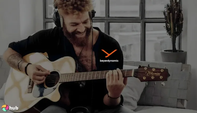 Image from the official Beyerdynamic website showing a man playing guitar while wearing headphones