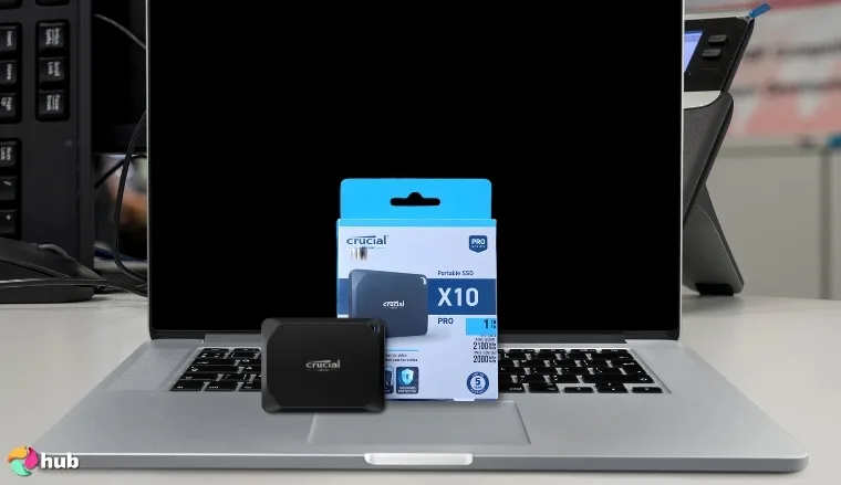 Crucial X10 Pro SSD on a white office desk in a top-down view for a review