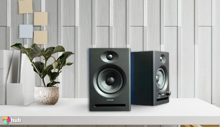 Ortizan C7 Speakers on a white office desk with decorative items for a review