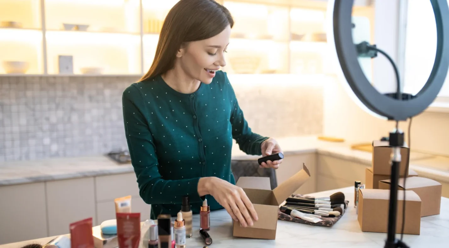 Woman unpacking a box in front of camera