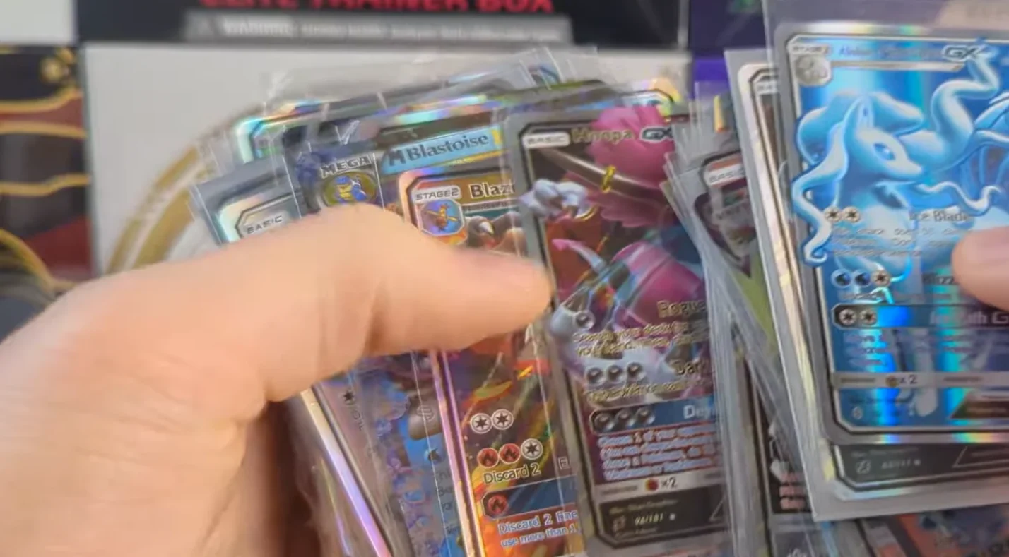 a bunch of Pokemon cards in hands