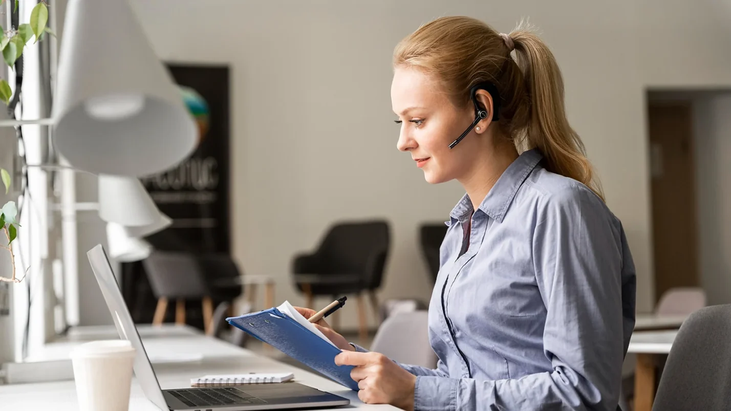 Woman with headphones sitting in front of laptop