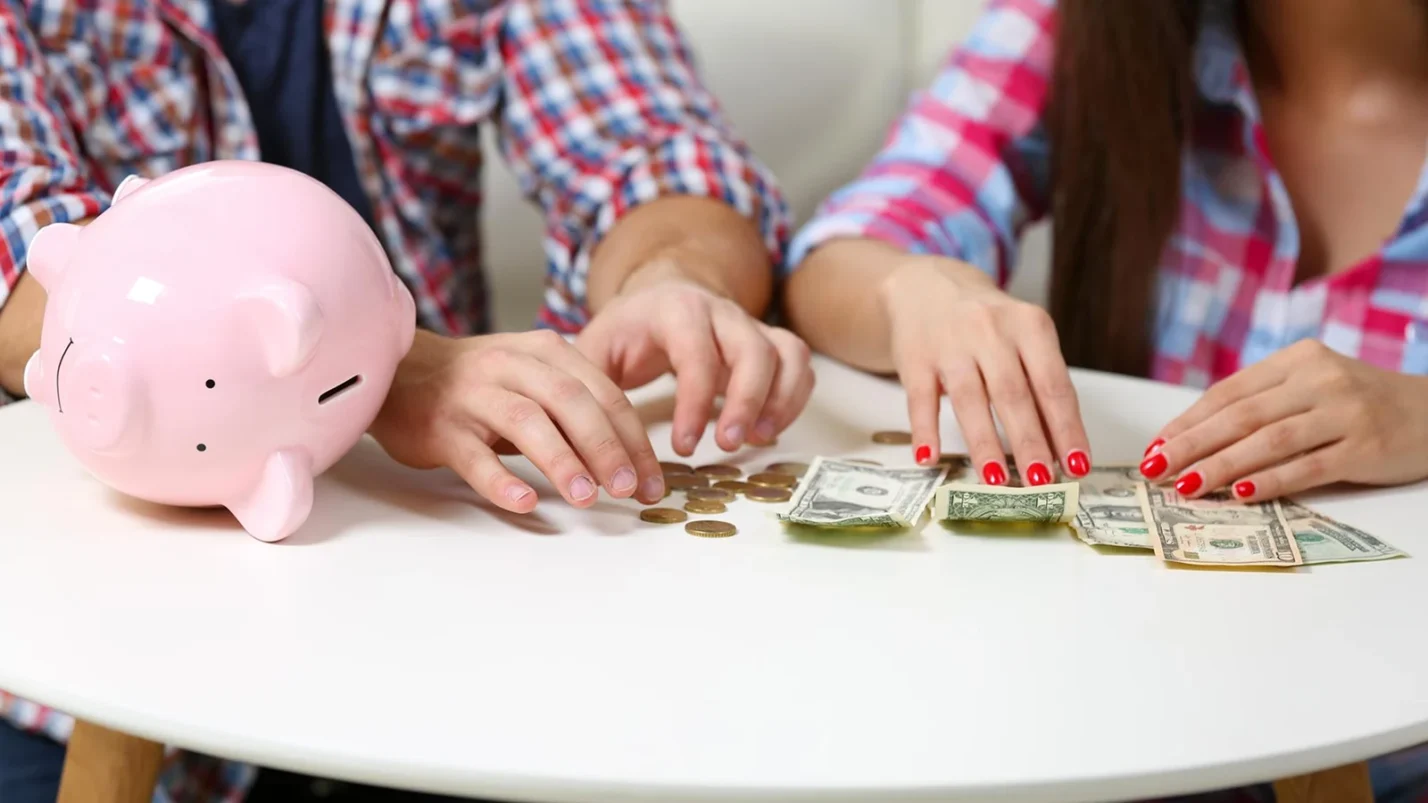 A couple sitting at table and counting money