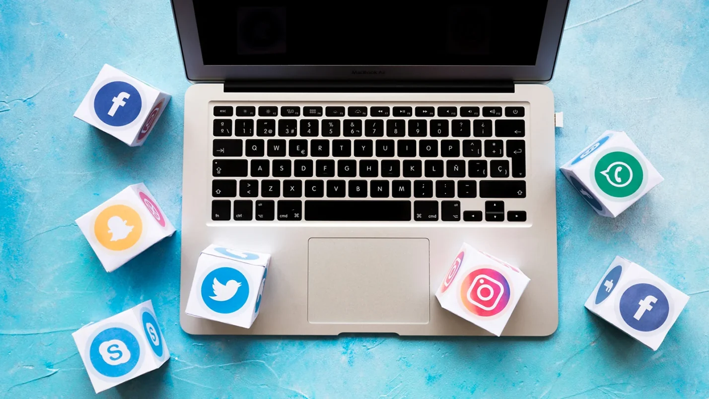 laptop surrounded with different icons of social media