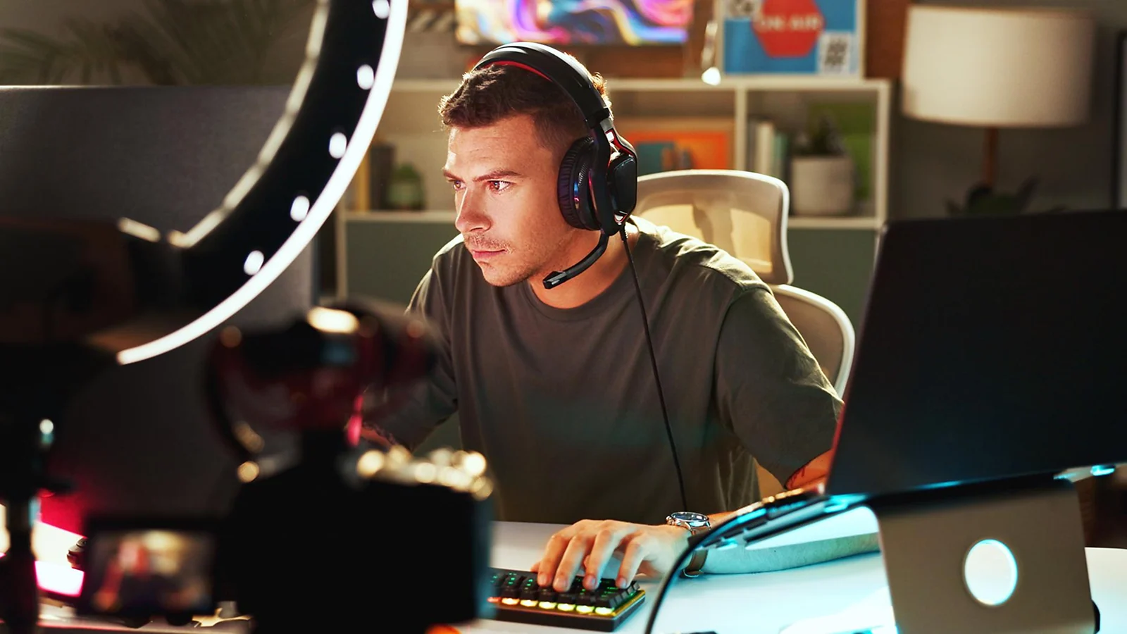 Man wearing headphones typing on a keyboard at a desk