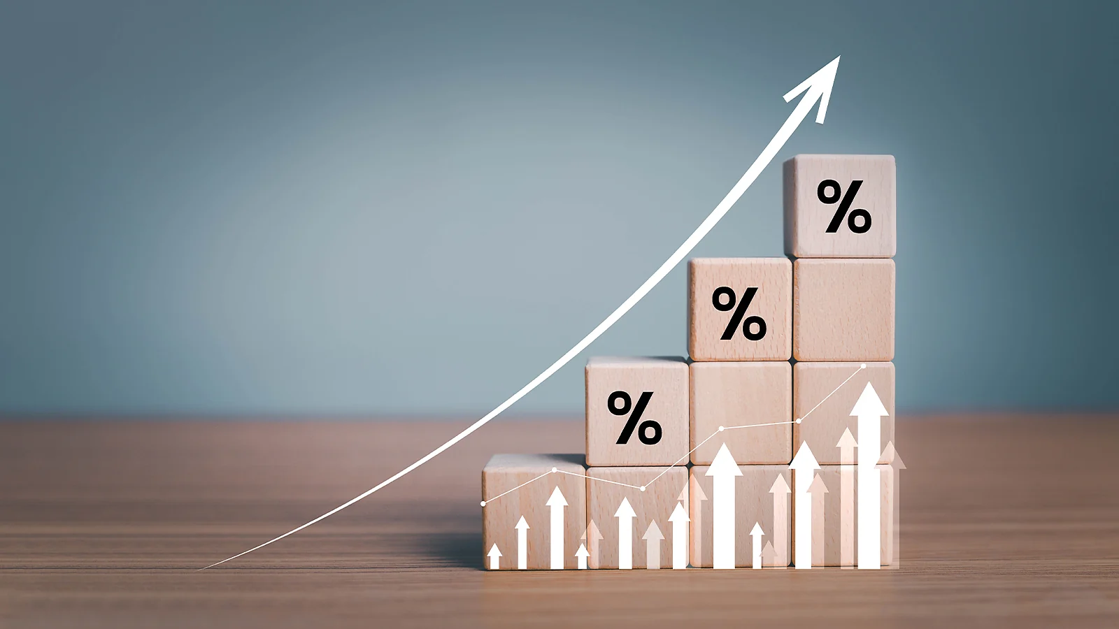 Wooden blocks stacked like a bar graph with percentage symbols and a white arrow pointing upward