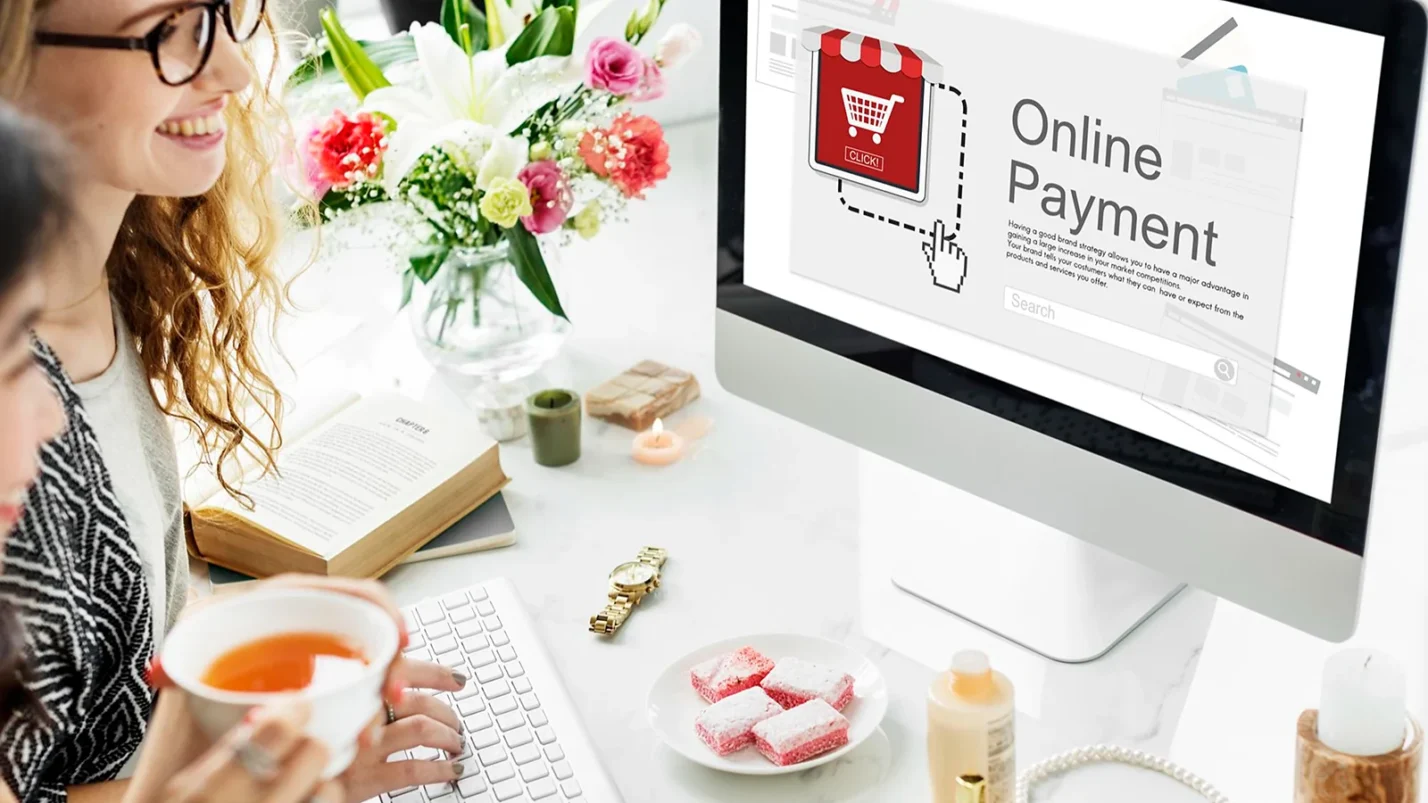 two women sitting in front of laptop where is written Online payment