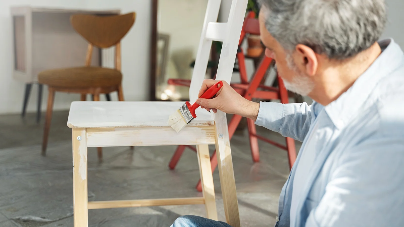 A man painting a chair