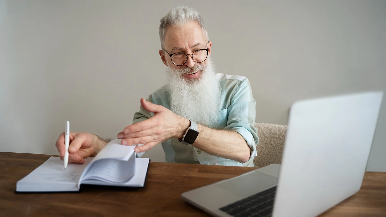 A bearded man sitting in front of a laptop