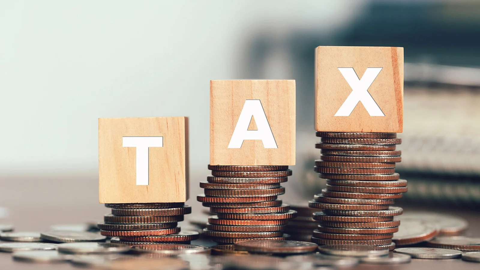 Coins and the word ‘TAX’ written on wooden cubes