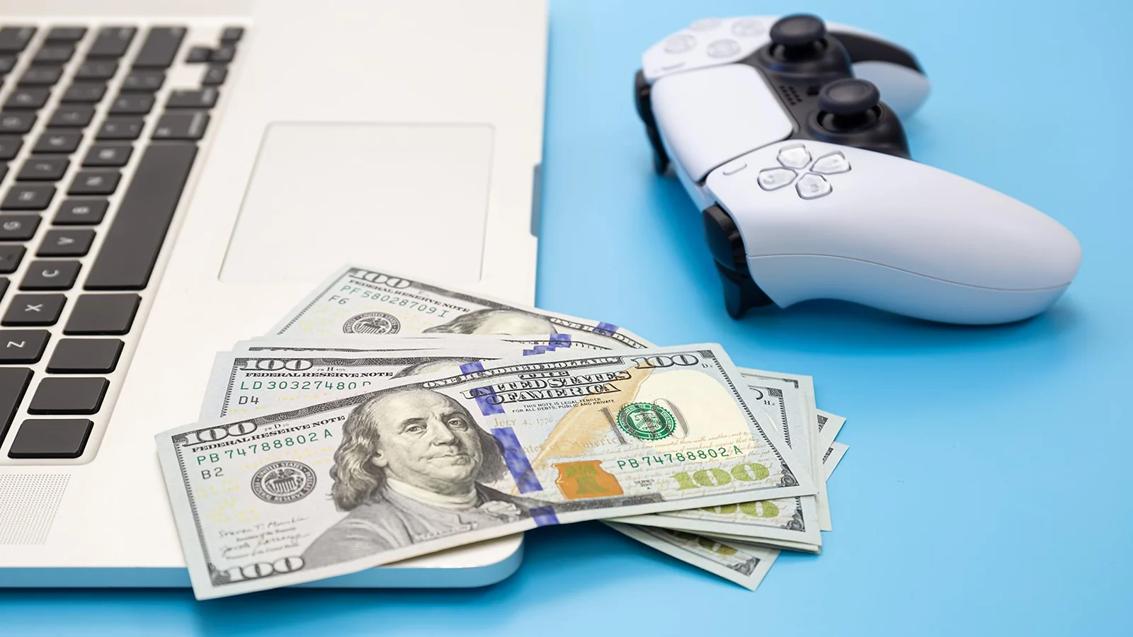 Laptop, controller and dollars bills