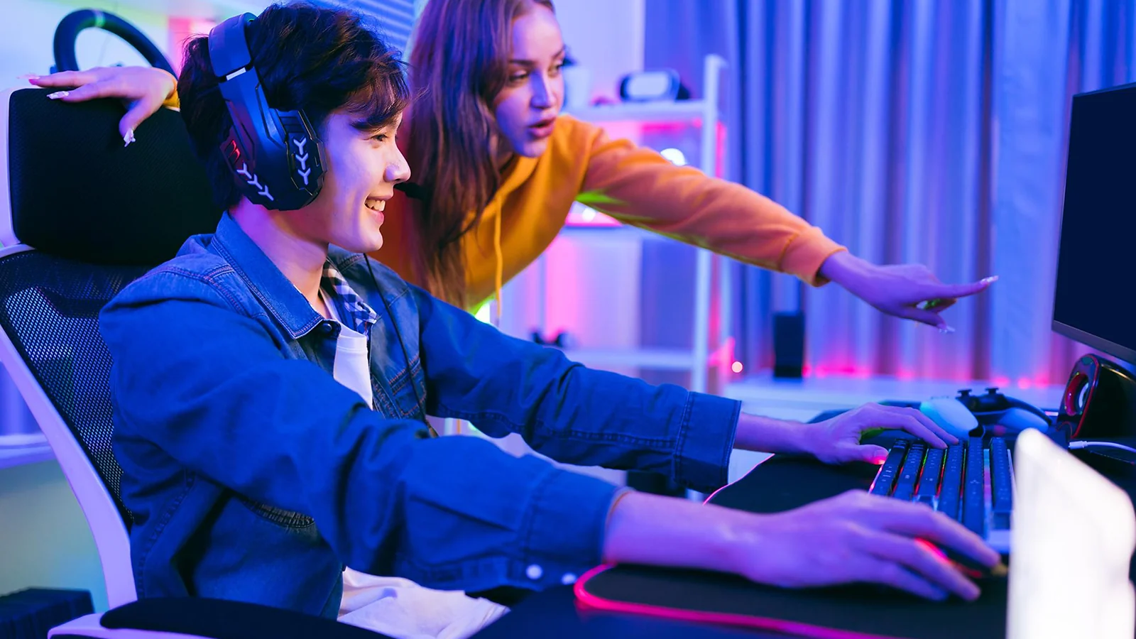 A girl explaining something to a boy with headphones 