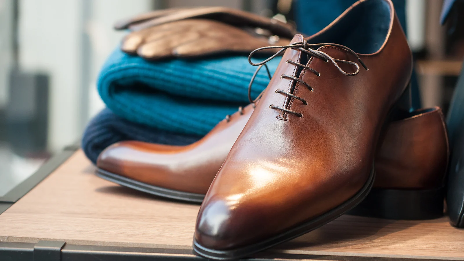 Close-up of high-quality vintage leather dress shoes and folded clothing ready for resale