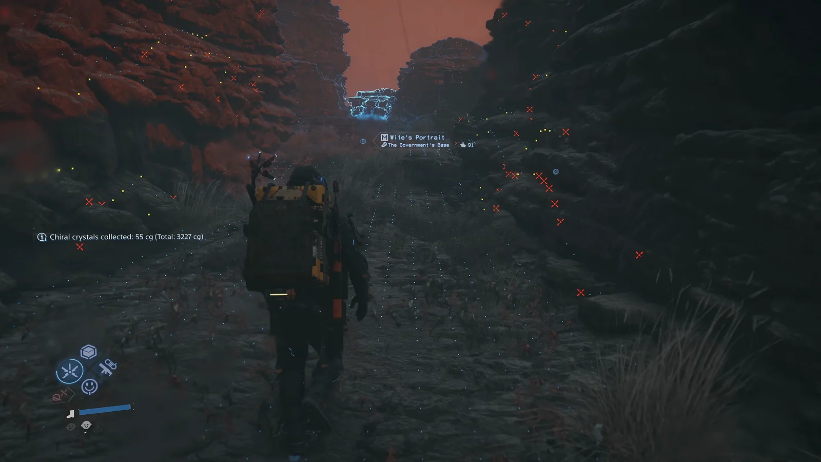 Sam walking through a dark rocky canyon with glowing chiral crystals and waypoint markers visible